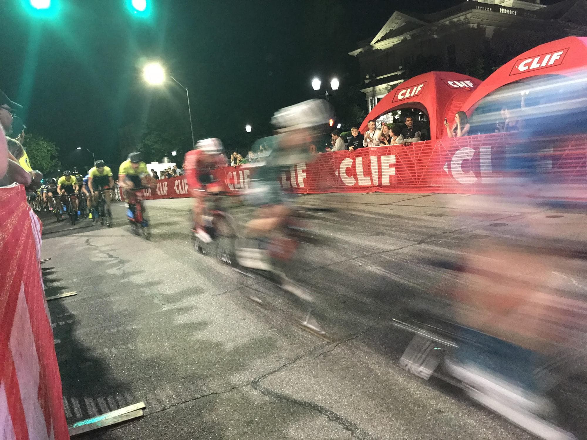 A criterium field blurring past under the lights at Athens Twilight